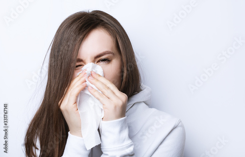 woman sneezes into a napkin