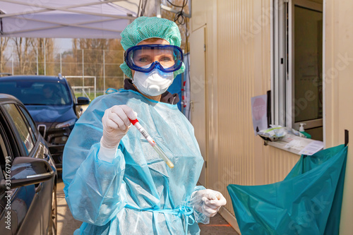 Ärztin an einer Teststation mit Coronavirus Test in der Hand  photo