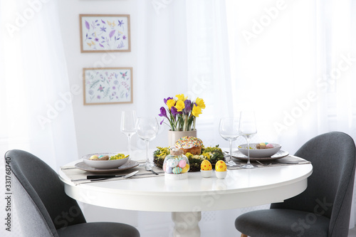 Festive Easter table setting with beautiful flowers and eggs indoors