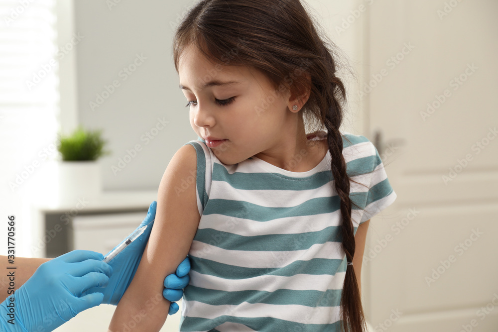 Doctor vaccinating little child in modern clinic Doctor vaccinating little child in modern clinic