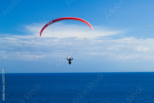 paragliding fly above the clouds in the blue sky and sea