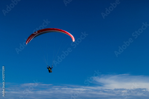 paragliding fly above the clouds in the blue sky
