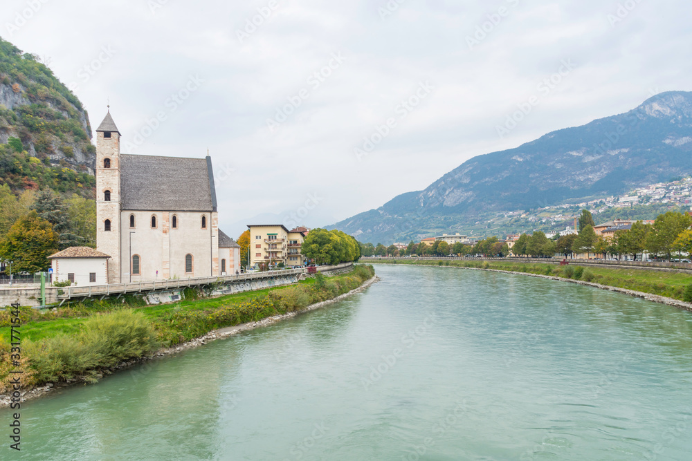 View to the church St Apollinare in Trento, Italy. The river etsch in the center.