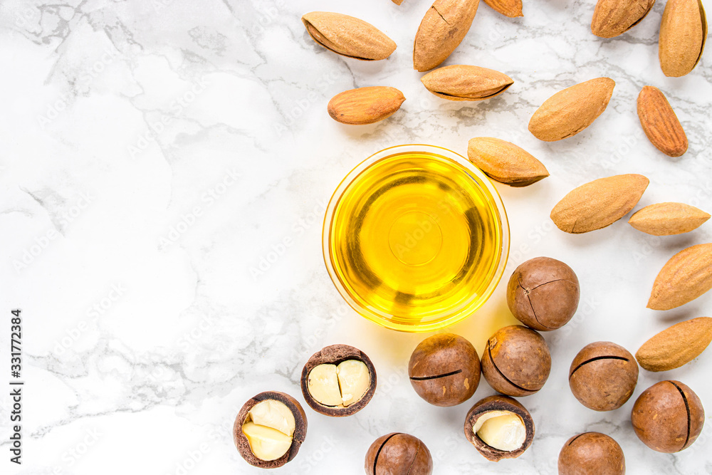 almond and macadamia oil on a white marble background. The concept of healthy vegan food and natural cosmetics. Flat lay. almond and macadamia oil on a white marble background. The concept of healthy vegan food and natural cosmetics. Flat lay.