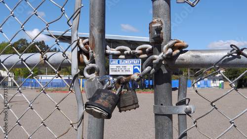 Close up of locked gate on a school closed due to coronavirus. All logos removed.
