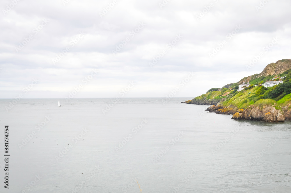 Howth island on ireland, near dublin. cloudy sky and green island, perfect place for hiking and relaxing.