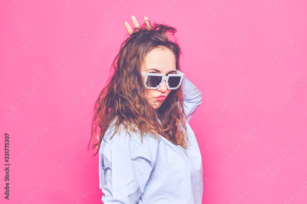 Stylish caucasian girl in a pale blue t-shirt and 8-bit glasses. Screaming at the camera. Toned. Stylish caucasian girl in a pale blue t-shirt and 8-bit glasses. Screaming at the camera. Toned.