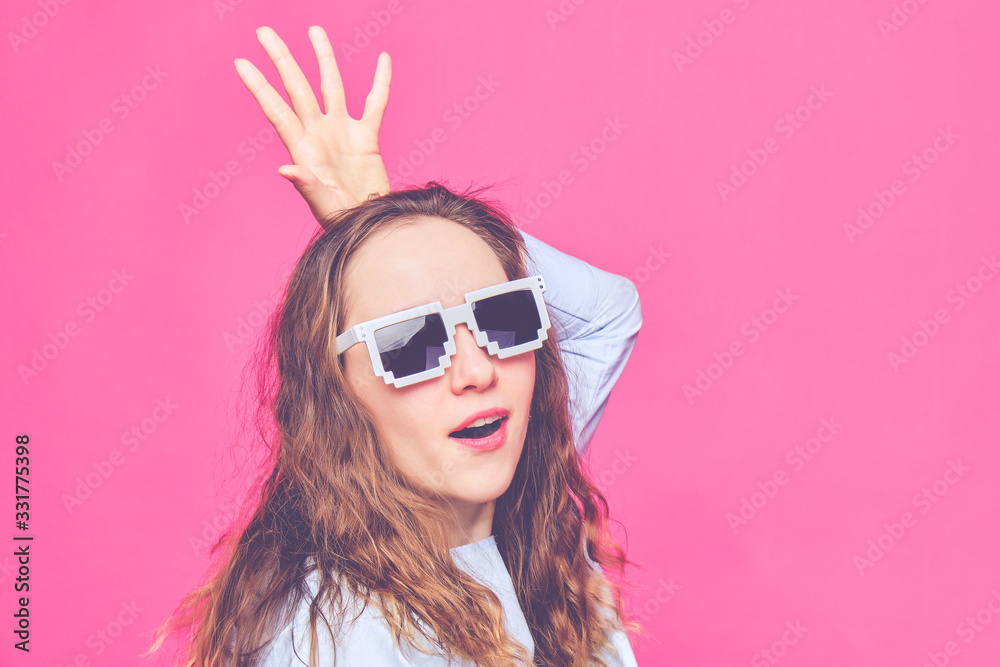 Stylish caucasian girl in a pale blue t-shirt and 8-bit glasses. Screaming at the camera and portray the queen. Toned. Stylish caucasian girl in a pale blue t-shirt and 8-bit glasses. Screaming at the camera and portray the queen. Toned.