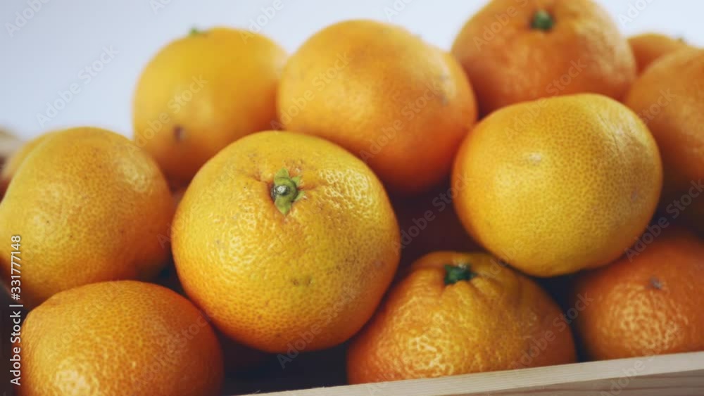 Fresh harvest of tangerines in a wooden box close-up Fresh harvest of tangerines in a wooden box close-up