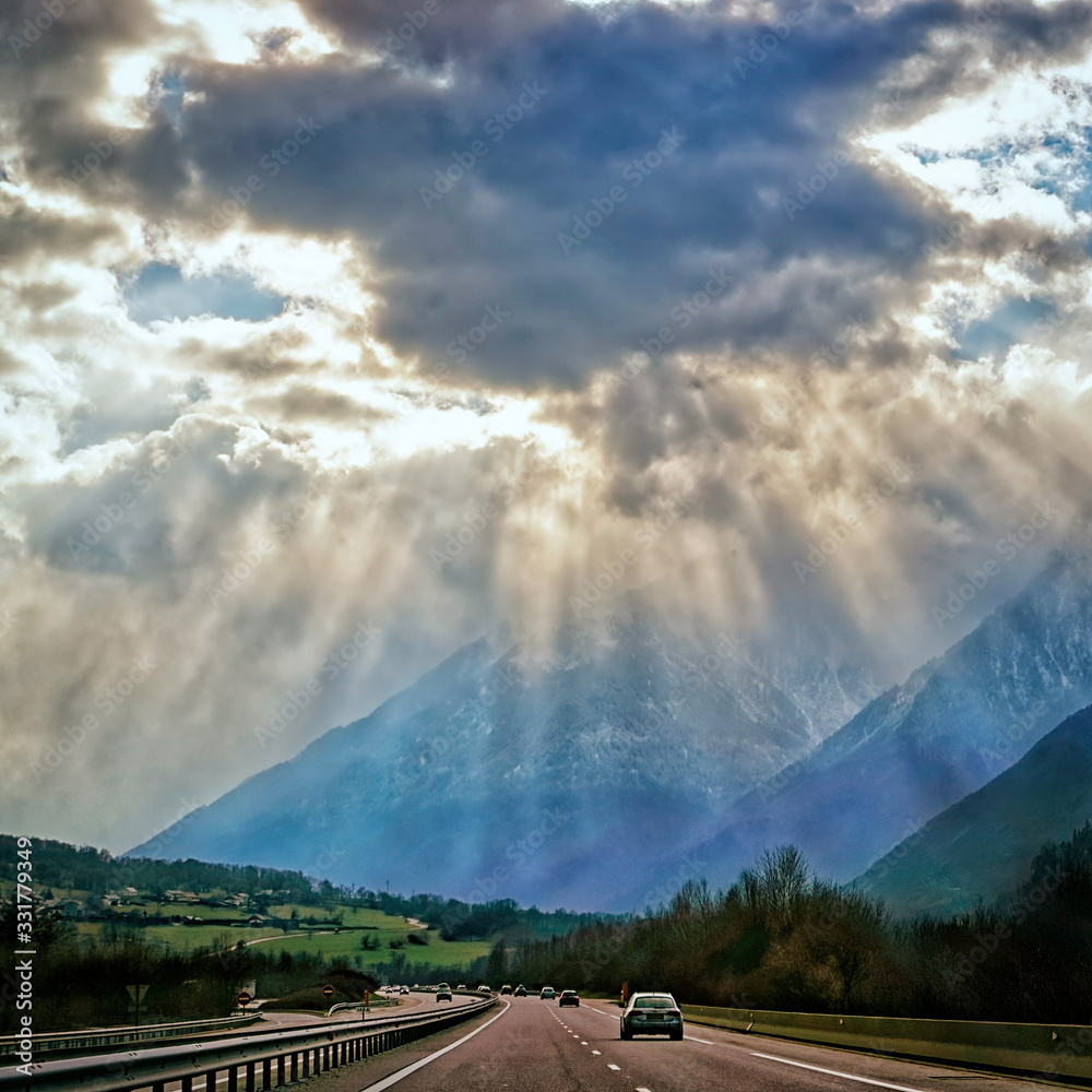 Spectacular sun rays over the road in french alps