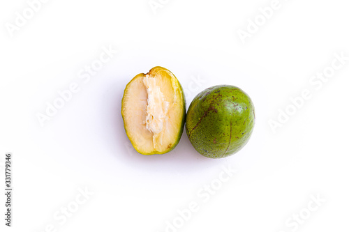 fresh green ambarella fruit that is still intact and that has been cut, isolated from a white background and copyspace, scientific name: Spondias dulcis