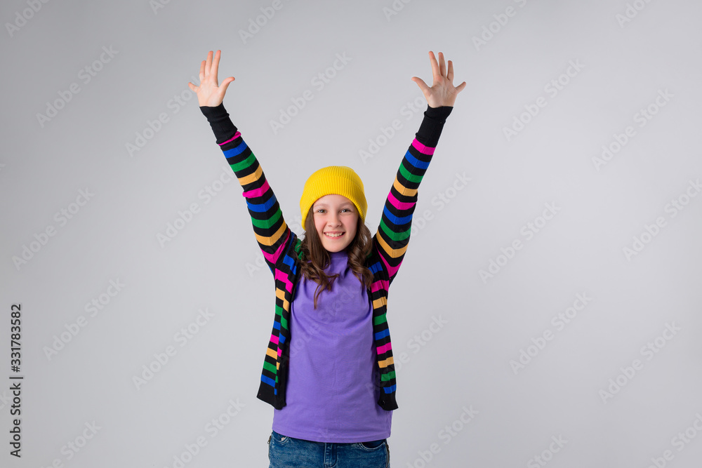Happy schoolgirl in purple T-shirt and yellow hat on white background Happy schoolgirl in purple T-shirt and yellow hat on white background