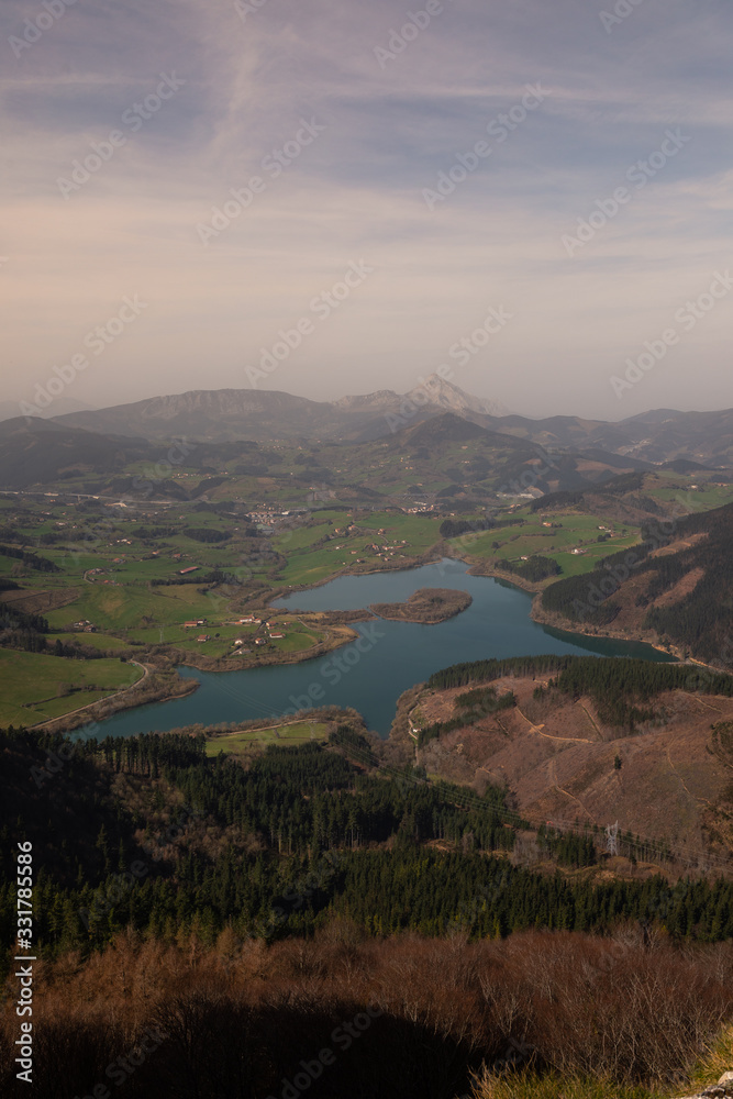 Urkulu reservoir surronded by mountains seen from the top of Orkatzategi hill, in Aretxabaleta, Basque Country.