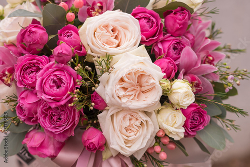 Fotografía Woman florist making a lovely Flower composition in round hat box of  roses in girl hands