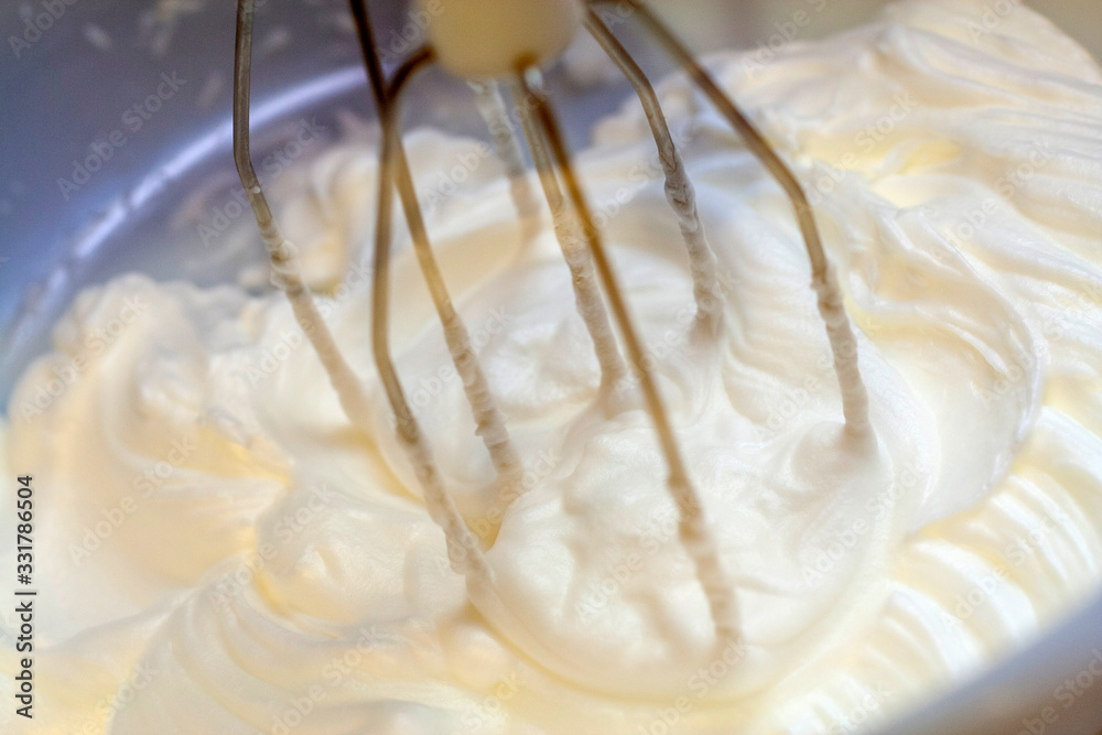 Mixing white egg cream in bowl with electric mixer, baking cake Mixing white egg cream in bowl with electric mixer, baking cake
