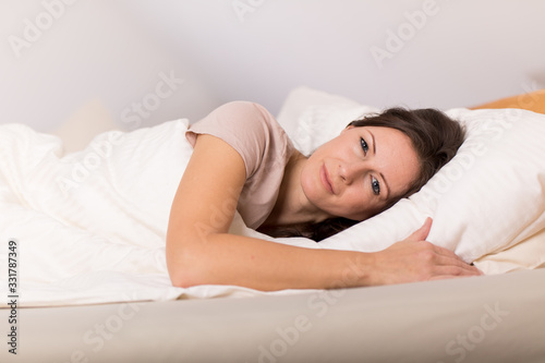 Frau träumt mit offenen Augen im Bett