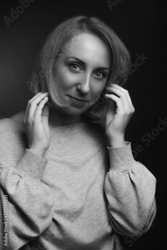 Classic black-and-white dramatic portrait of an blonde woman in Studio on black background.