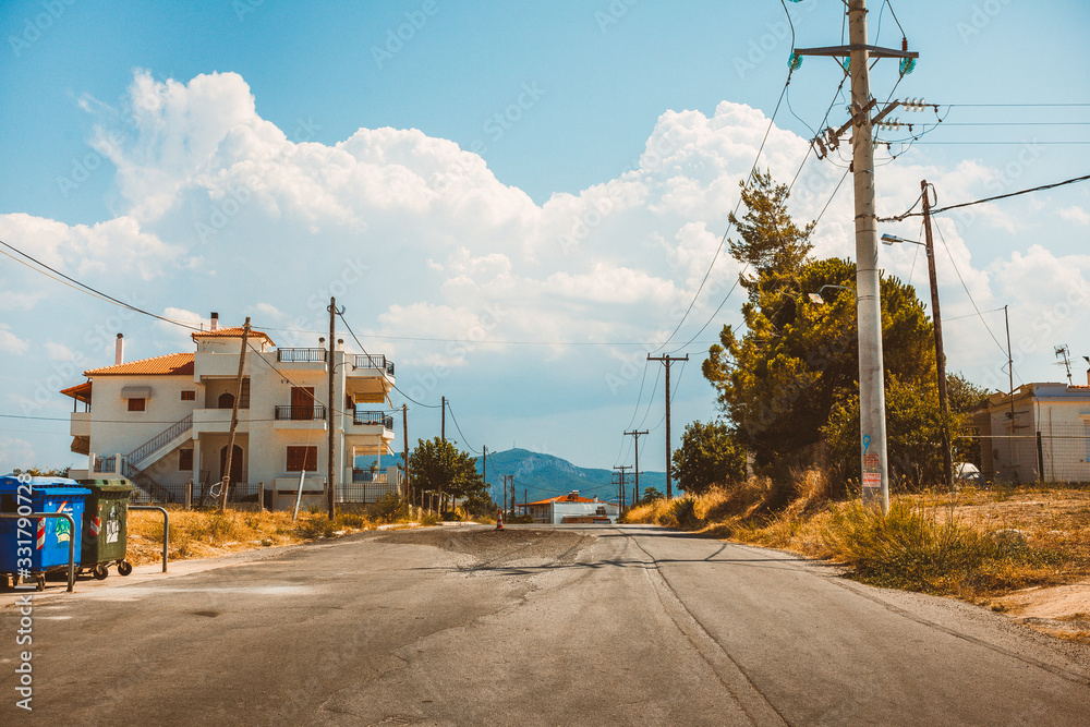 Empty rural road going through prairie under cloudy sky in Greece, Corinth. Vintage style processing image.