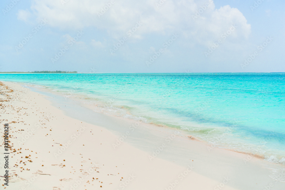 Idyllic tropical beach in Caribbean with white sand, turquoise ocean water and blue sky