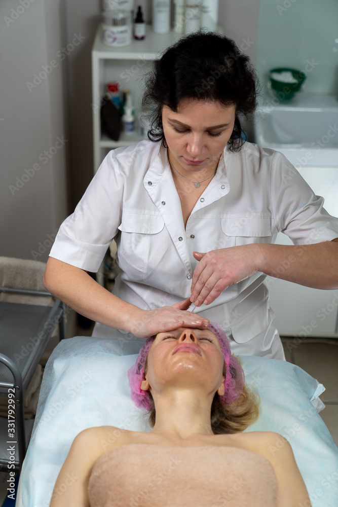 Obraz premium Beautician makes a procedure for a girl to improve facial skin condition