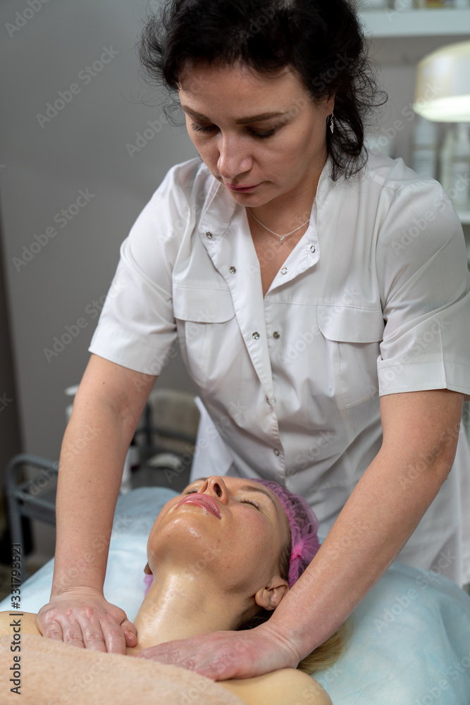 Obraz premium Beautician makes a procedure for a girl to improve facial skin condition