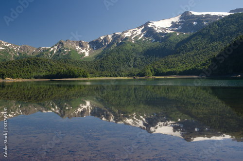 Cliffs and forest reflected on the Conguillio lake.