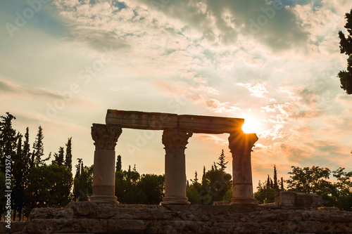 Siluette of anchient ruins of temple in Corinth, The lights of sun brights through. Greece - archaeology background