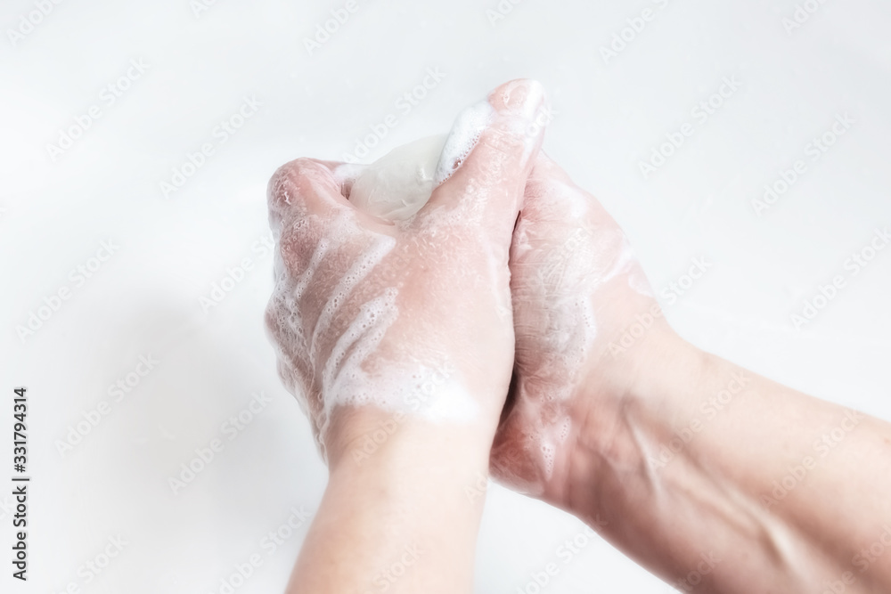 Washing hands with soap under the faucet with water