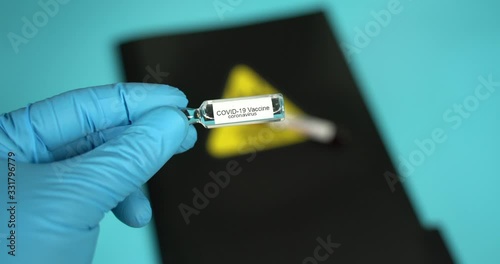 Doctor holds COVID 19 Coronavirus vaccine in his hand, infected blood sample in the sample tube, Vaccine and syringe injection It use for prevention, immunization and treatment from COVID-19