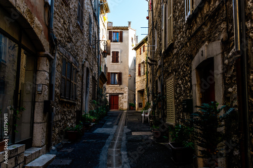 A narrow small street in the old medieval center of a French town in the morning after rain (Vence, France)