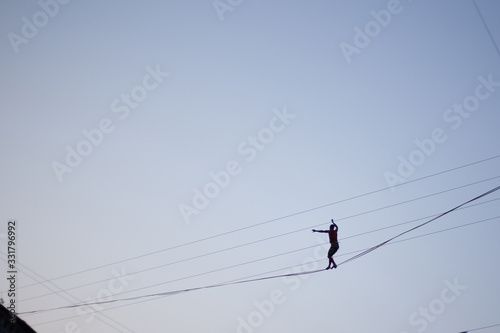 Man balancing on a rope against the sky