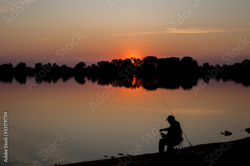 Fisherman at dawn fishing on a fishing rod