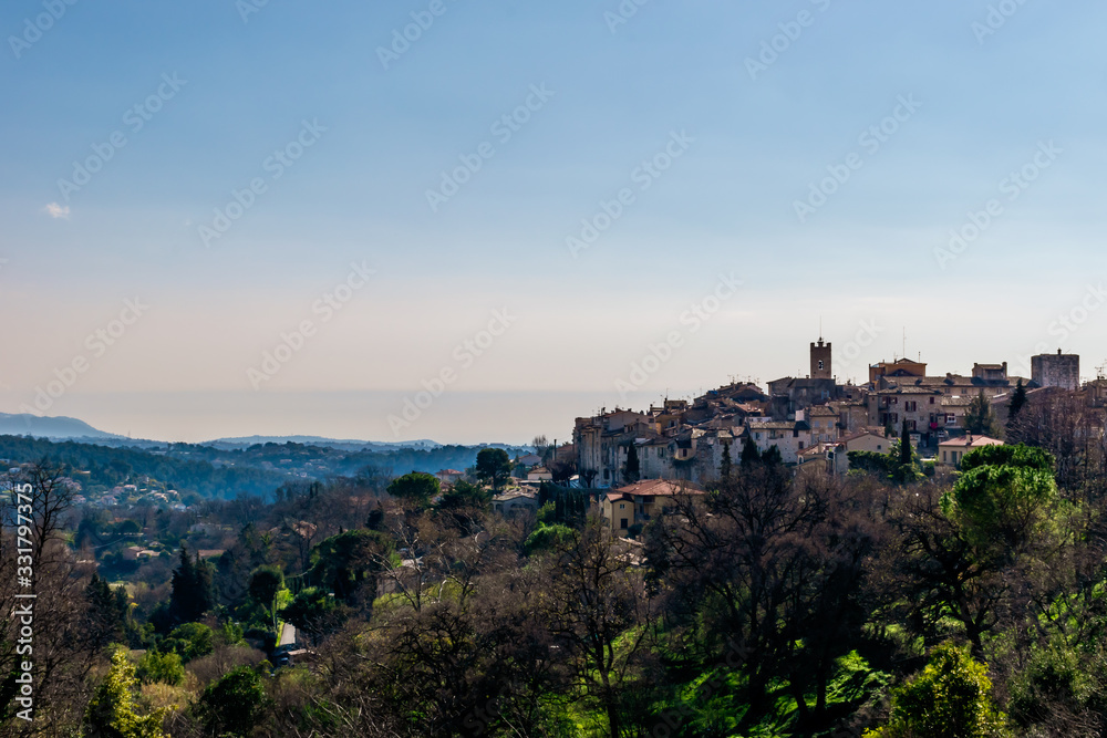 A panoramic view of the old French town Vence and its medieval architecture and buildings along with forest and the low Alps mountains hills (Provence / Riviera / Côte d'Azur)