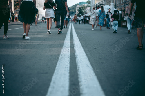 Two white lines on the road where people walking