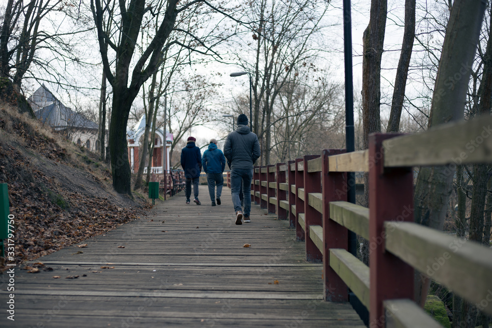 Four guys stand on the bridge near the river