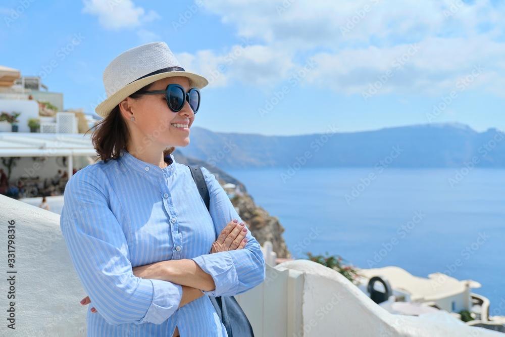 Tourist business, businesswoman posing of landscape of Oia Santorini