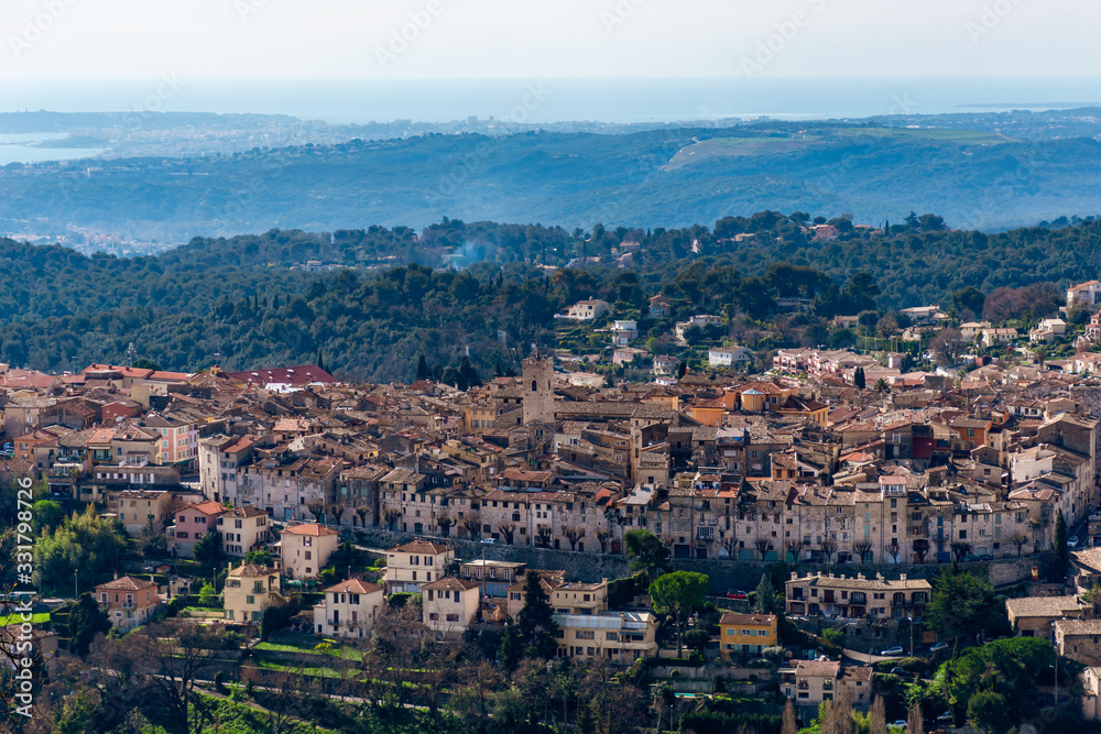A close-up panoramic view of the old medieval French town Vence with the low Alps mountains hills, the Mediterranean Sea and forests in the background (Provence / Riviera / Côte d'Azur)