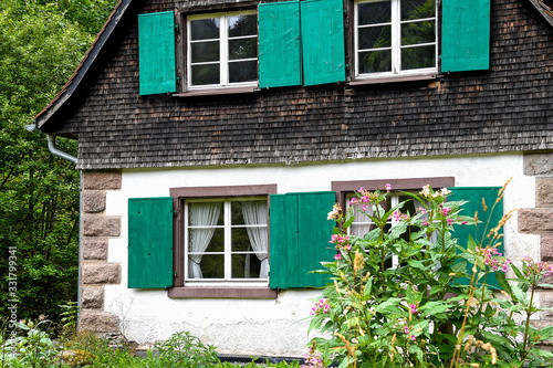 exterior of quaint old cottage with green shutters