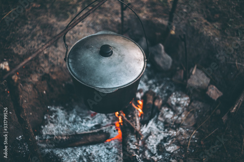 Cauldron with soup on a campfire in a hike