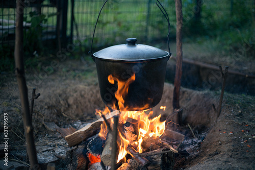 Cauldron with soup on a campfire in a hike