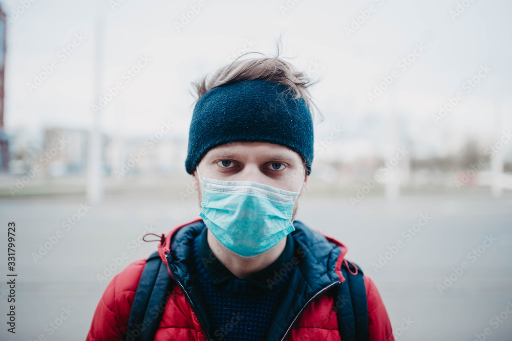 young man in a medical mask in a city during a pandemic. young man in a medical mask in a city during a pandemic.