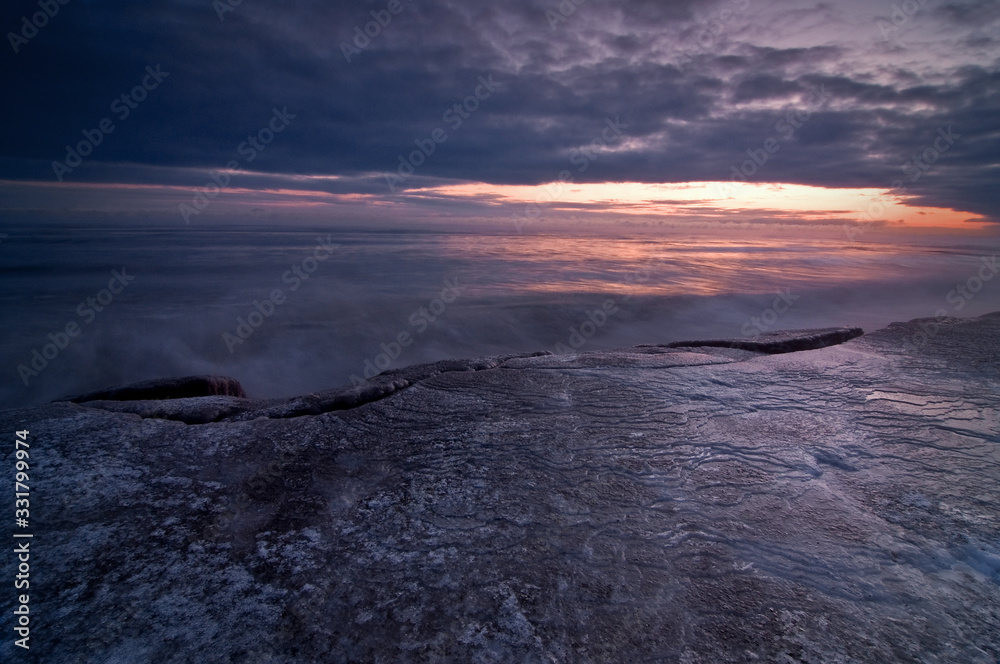 Fototapeta premium Great Lakes Winter Sunrise over Lake Michigan on a cold January morning at Openlands Lakeshore Preserve,. Fort Sheridan, Illinois.