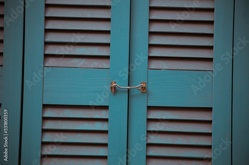 Blue louvred door with metal latch