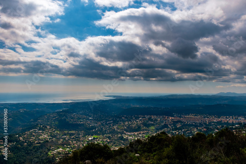 A panoramic view of several towns and their buildings densely covering the low Alps mountains hills with the Mediterranean Sea on the horizon (Provence / Riviera / Côte d'Azur) © k.dei