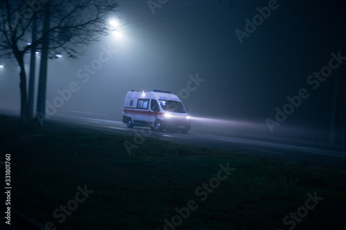 Ambulance rushes in the fog at night © Hennadii