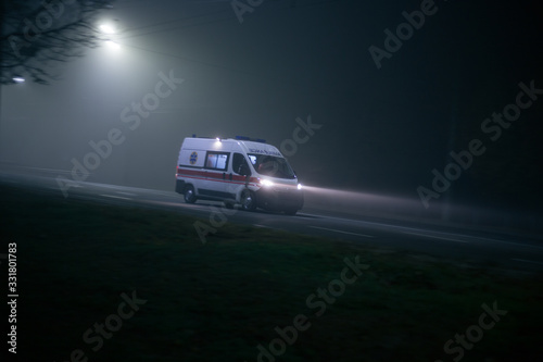 Ambulance rushes in the fog at night