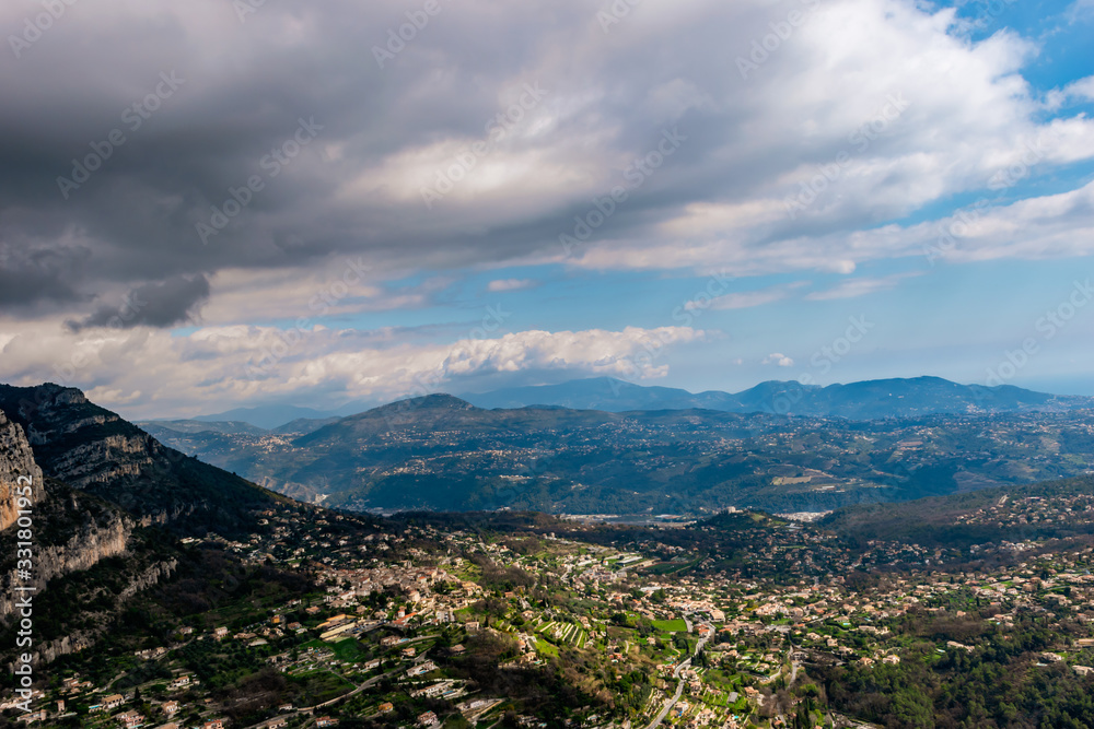 A wide / high angle panoramic view of Saint-Jeannet buildings and other towns covering the low Alps mountains hills with the mountain ranges in the haze (French Côte d'Azur/ Provence/ Riviera)
