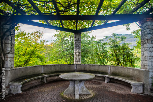 Un pergolato con tavolo di marmo e panca nel giardino botanico di Villa Taranto, Verbania, Italia photo