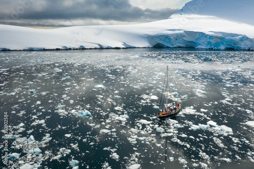 aerial view to alone yacht rides through icebergs in Antarctica
