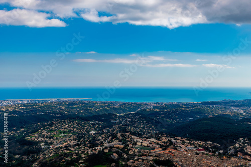 A wide   high angle panoramic view of buildings of several towns  including Vence  covering the low Alps mountains hills and the Mediterranean Sea coastline  French C  te d Azur  Provence  Riviera 